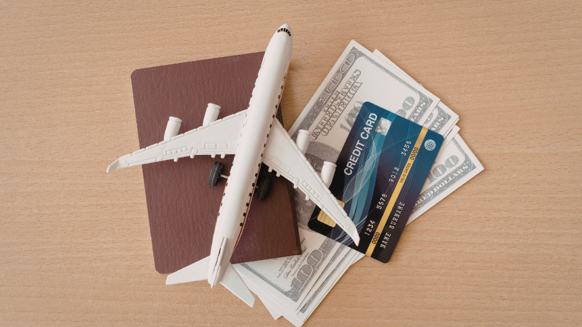 Toy airplane on passport with cash and credit card for travel budget concept